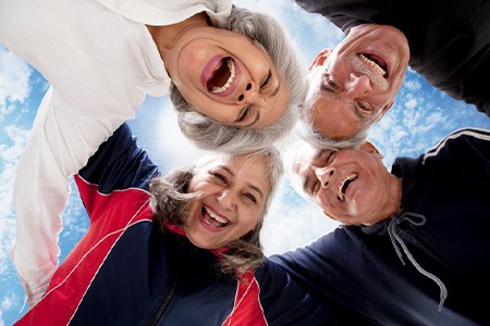 Group of friends smiling down at the camera on a sunny day