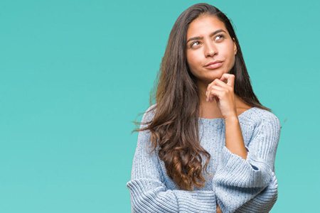 Woman touching her chin and looking quizzical 