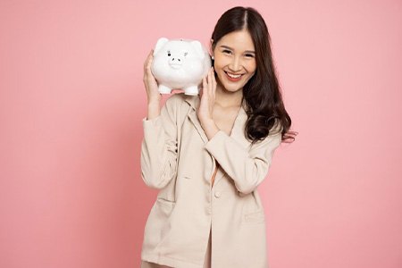 Woman holding a piggy bank and smiling