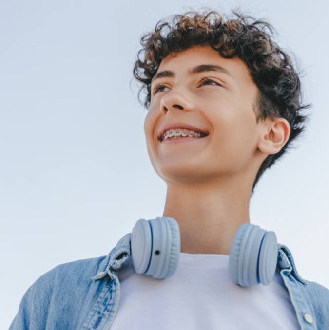 a teenager smiling while wearing braces